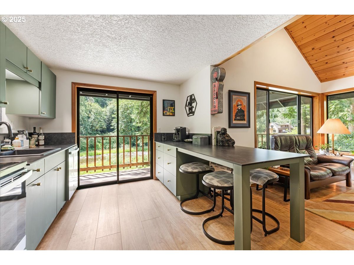 1717 Kalama River Road Kalama, WA 98625 - Photo 7 of 48 a open kitchen with granite countertop a stove a sink dishwasher a dining table and chair with wooden floor