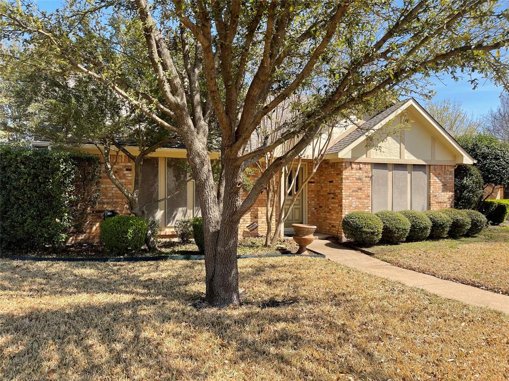 a front view of a house with a yard covered with snow and trees