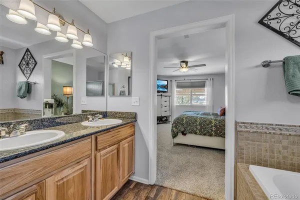 a en suite bathroom with a granite countertop sink and a mirror
