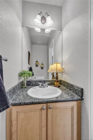 a bathroom with a granite countertop sink and a mirror