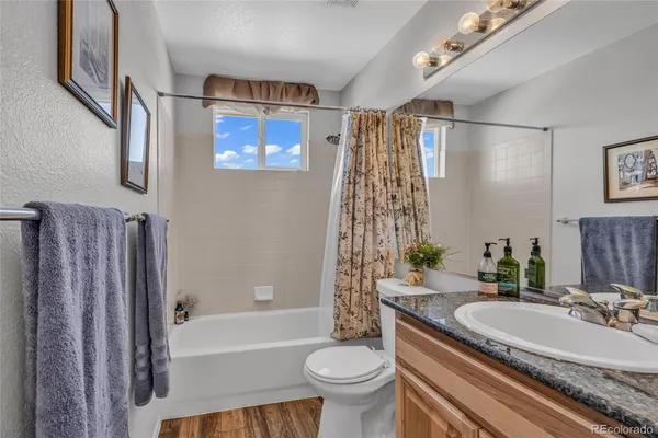 a bathroom with a granite countertop sink toilet and shower