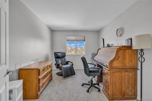 a view of a workspace with furniture and a window