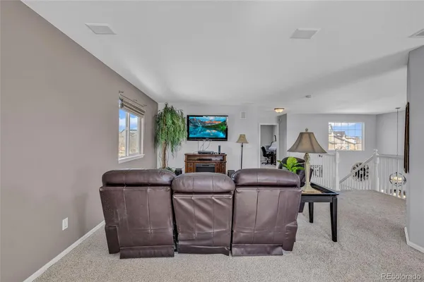 a living room with furniture a window and a flat screen tv