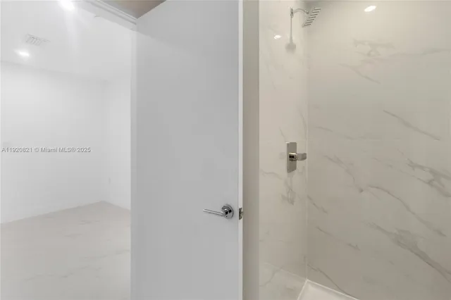 a view of an empty room with glass door and balcony