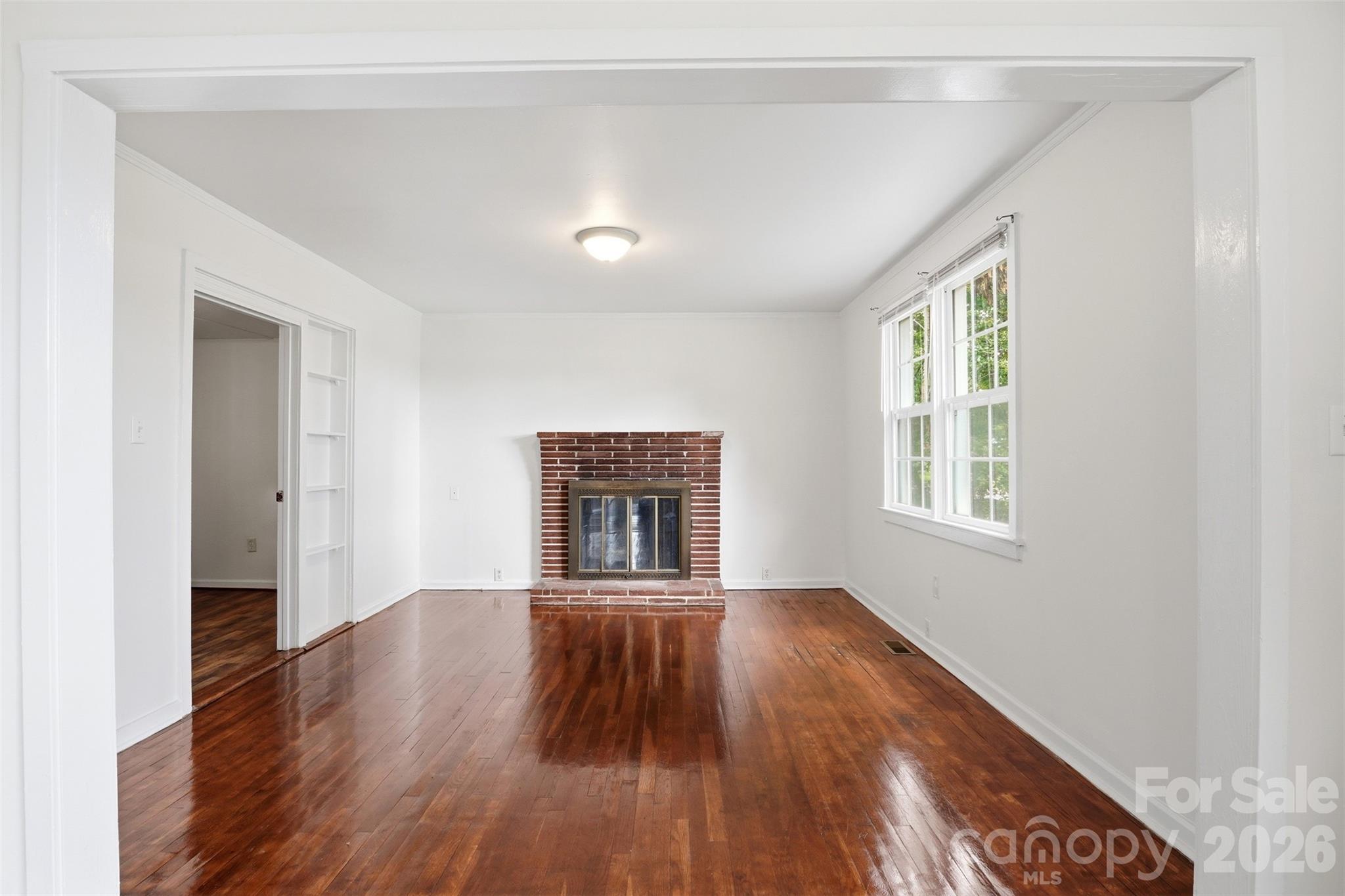 128 Ella Street Chester, SC 29706 - Photo 16 of 18 an empty room with wooden floor a fireplace and windows