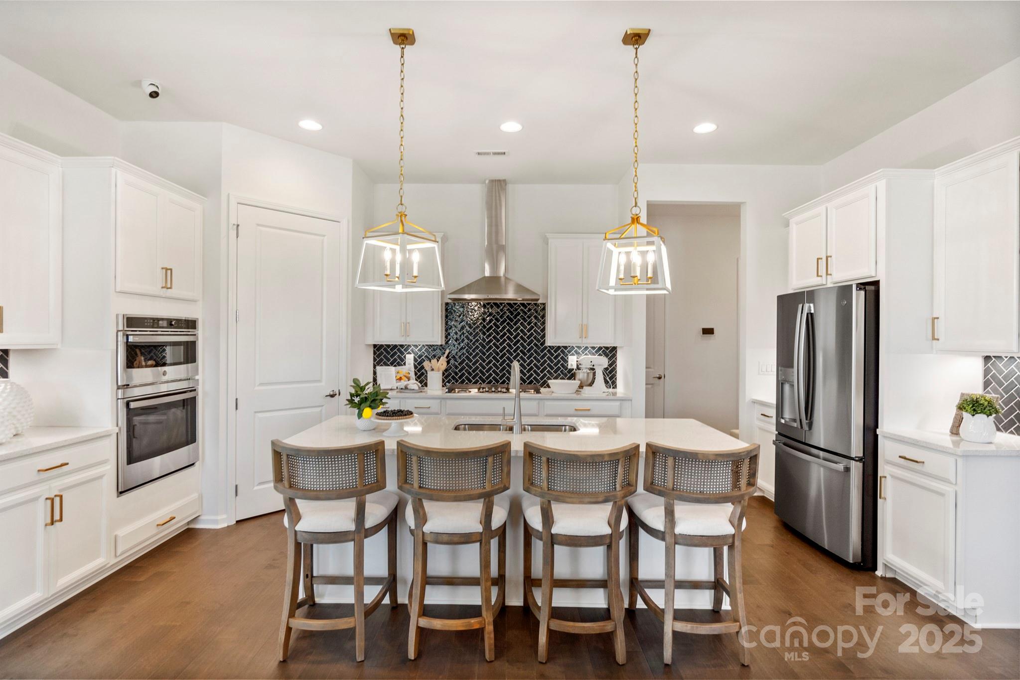 5068 Duval Circle Tega Cay, SC 29708 - Photo 7 of 41 a kitchen with kitchen island a dining table chairs stainless steel appliances and cabinets