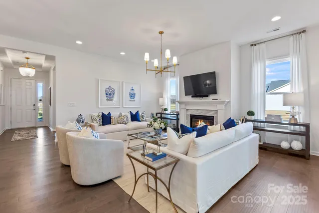 a living room with furniture kitchen view and a chandelier