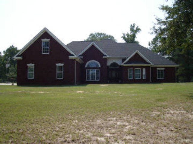 6267 Shines Road Macon, GA 31216 - Photo 1 of 1 a front view of a house with a garden