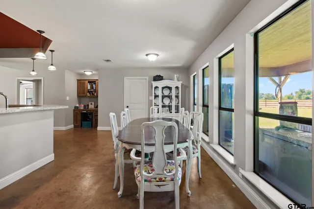 a dining room with furniture and a floor to ceiling window