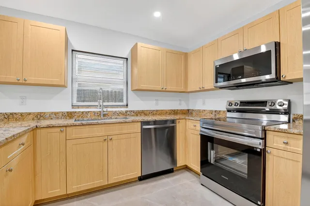 a view of a kitchen with center island and stainless steel appliances