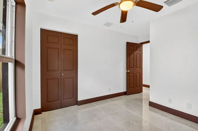 a bathroom with a granite countertop bathtub sink vanity mirror and toilet