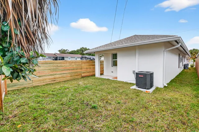 view of backyard with tub and utility room