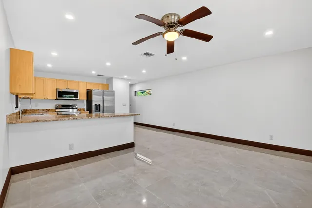 a kitchen with stainless steel appliances granite countertop a refrigerator and a stove top oven