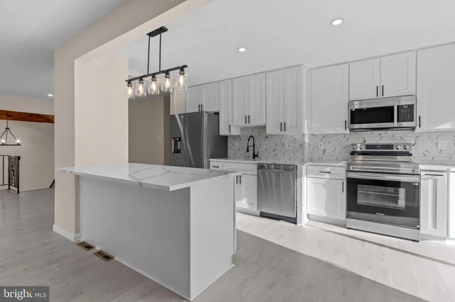 a kitchen with kitchen island a refrigerator stove and microwave