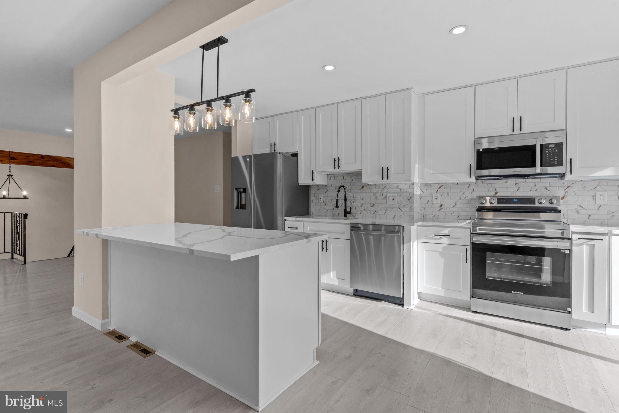 100 East Endfield Road Feasterville-Trevose, PA 19053 - Photo 15 of 53 a kitchen with kitchen island a refrigerator stove and microwave
