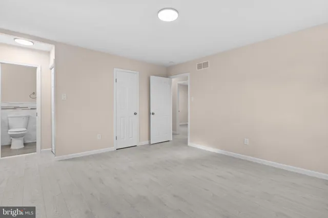 a bathroom with a granite countertop toilet sink and mirror