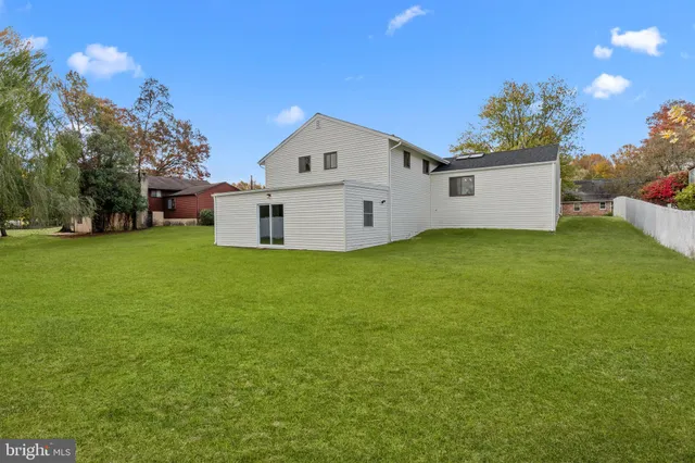 a view of backyard with large tree and wooden fence