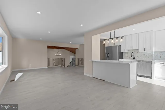 a view of a kitchen with a sink and dishwasher a refrigerator with white cabinets