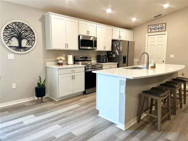 a kitchen with a sink stainless steel appliances and white cabinets