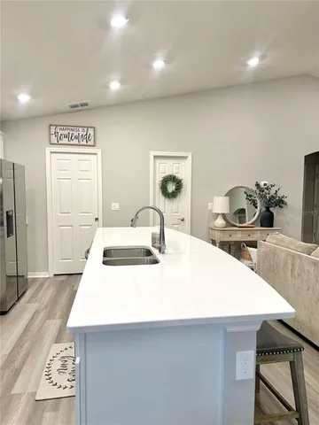a kitchen with kitchen island a sink stove and refrigerator