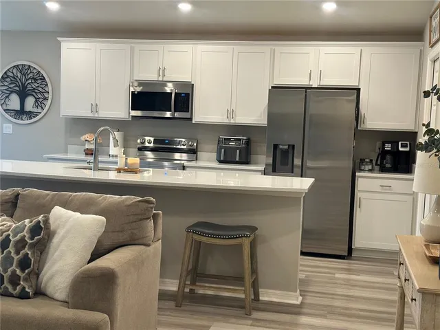 a kitchen with stainless steel appliances granite countertop a refrigerator a stove microwave and sink