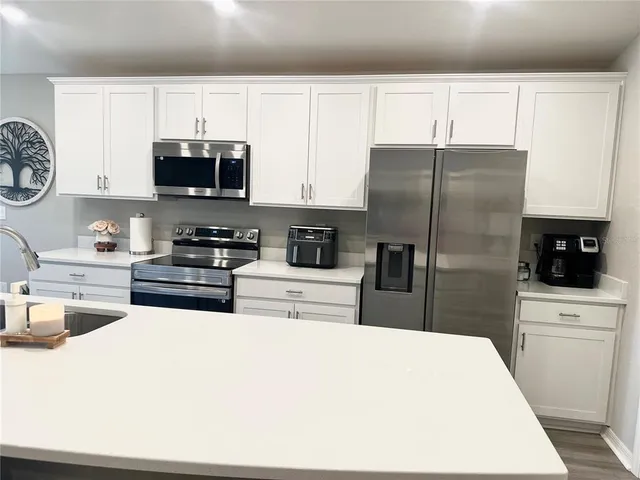 a kitchen with stainless steel appliances a refrigerator stove microwave and sink