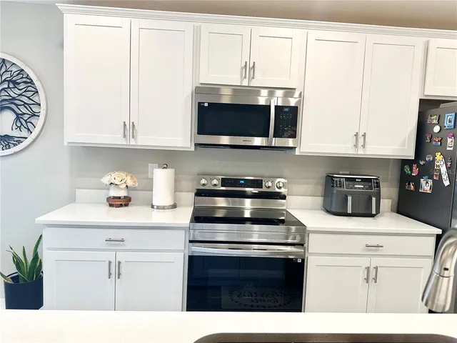 a kitchen with stainless steel appliances white cabinets and a sink