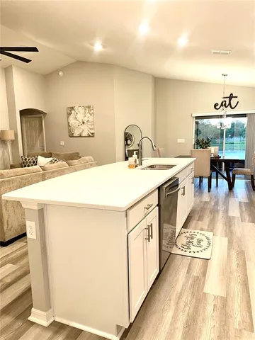a large white kitchen with wooden floor
