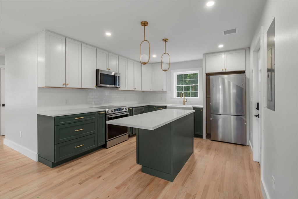 19 Whitehorse Road Hingham, MA 02043 - Photo 12 of 35 a kitchen with kitchen island granite countertop wooden floors stainless steel appliances and cabinets