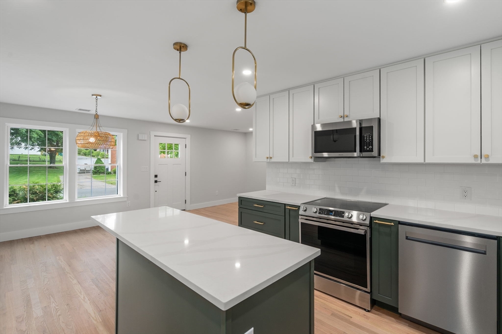 19 Whitehorse Road Hingham, MA 02043 - Photo 15 of 35 a kitchen with stainless steel appliances granite countertop a sink a stove a microwave and wooden floor