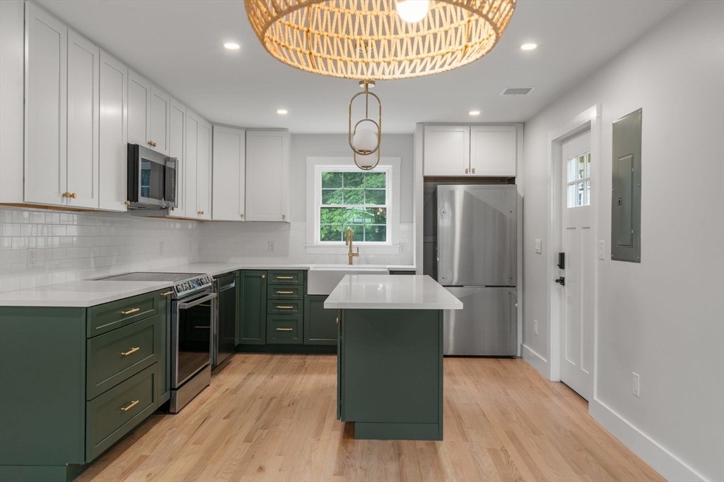 19 Whitehorse Road Hingham, MA 02043 - Photo 4 of 35 a kitchen with stainless steel appliances granite countertop a refrigerator a sink dishwasher a stove and a microwave oven with wooden floor