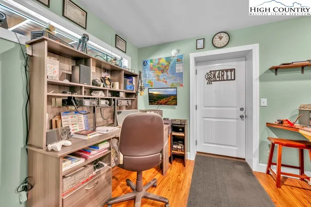 a living room with furniture appliances and wooden floor