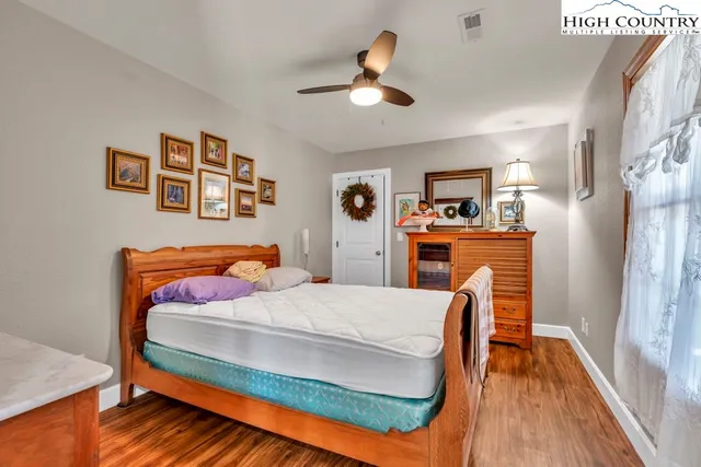 a bedroom with a bed and painting on the wall