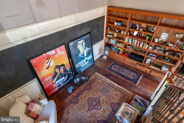 a room with kitchen island a dining table wooden floor and stainless steel appliances
