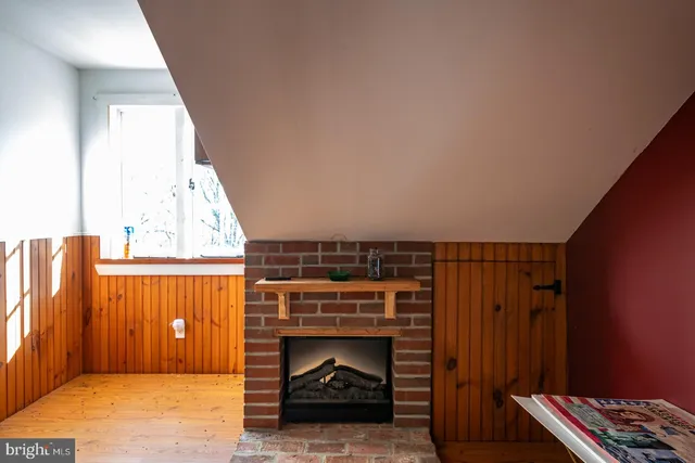 a backyard of a house with wooden fence and large trees