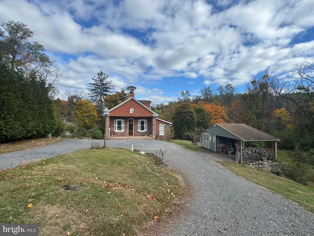 a view of a big house with a big yard and large trees