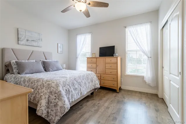 a spacious bedroom with a bed and a flat tv screen on dresser