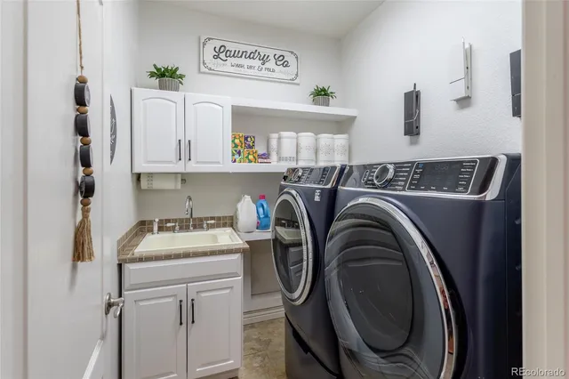 a utility room with sink dryer and washer
