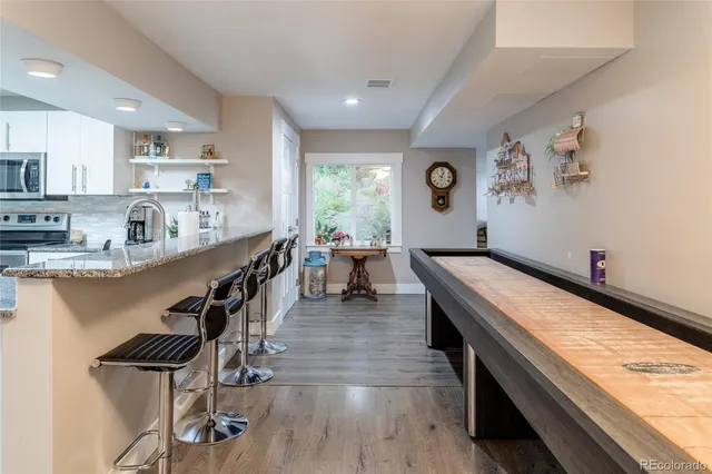 a large kitchen with cabinets stainless steel appliances a sink and a center island