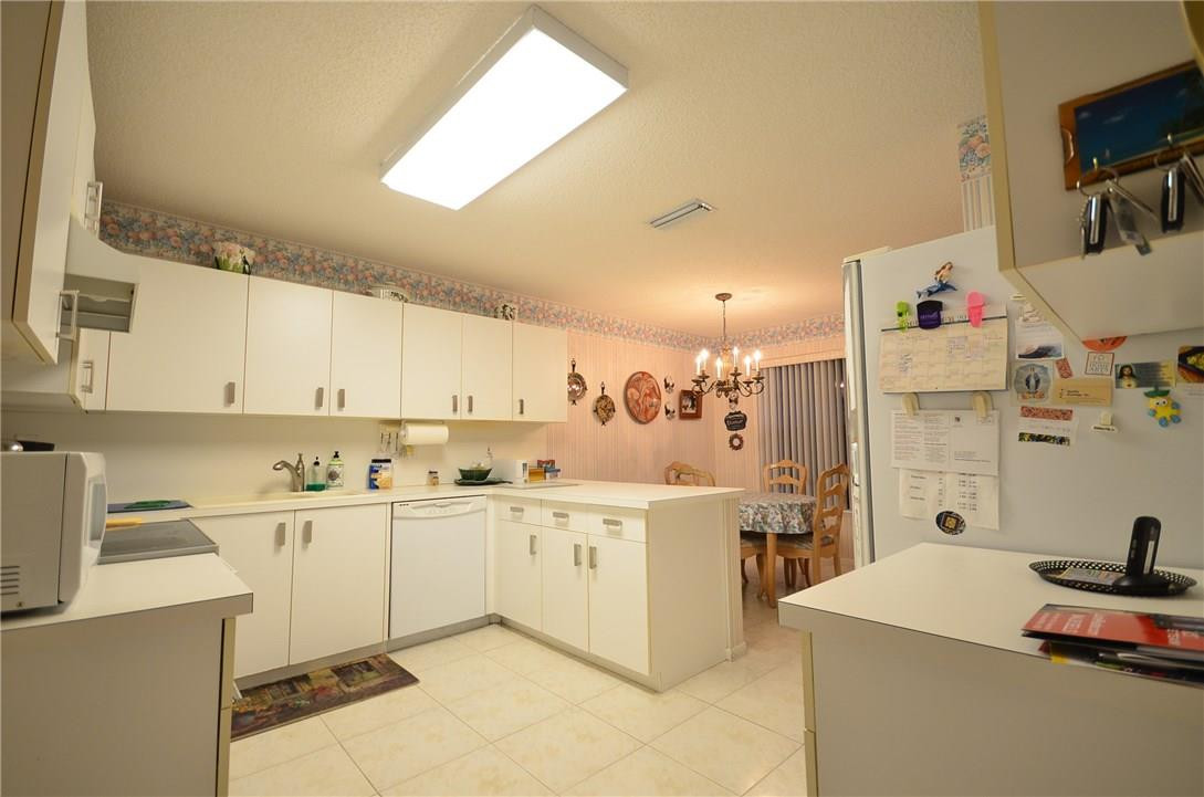 6761 Montego Bay Boulevard, Unit B Boca Raton, FL 33433 - Photo 11 of 34 a kitchen with stainless steel appliances and white cabinets