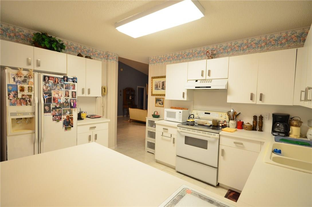 6761 Montego Bay Boulevard, Unit B Boca Raton, FL 33433 - Photo 13 of 34 a kitchen with stainless steel appliances a white refrigerator stove and white cabinets