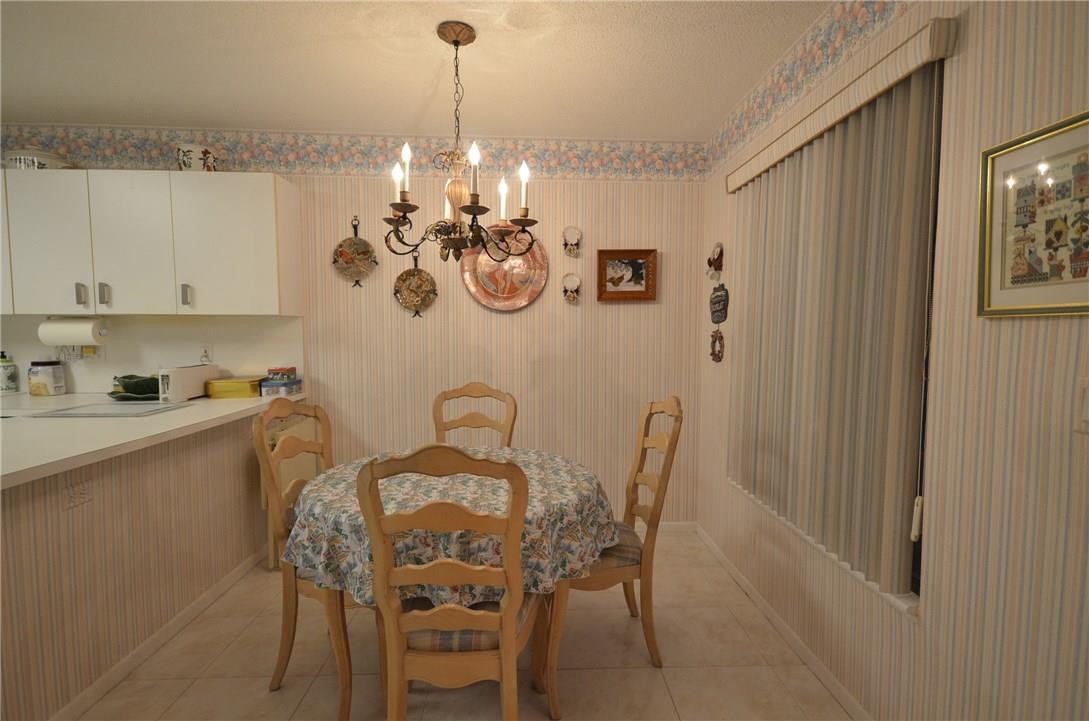 6761 Montego Bay Boulevard, Unit B Boca Raton, FL 33433 - Photo 15 of 34 a view of a dining room with furniture and chandelier