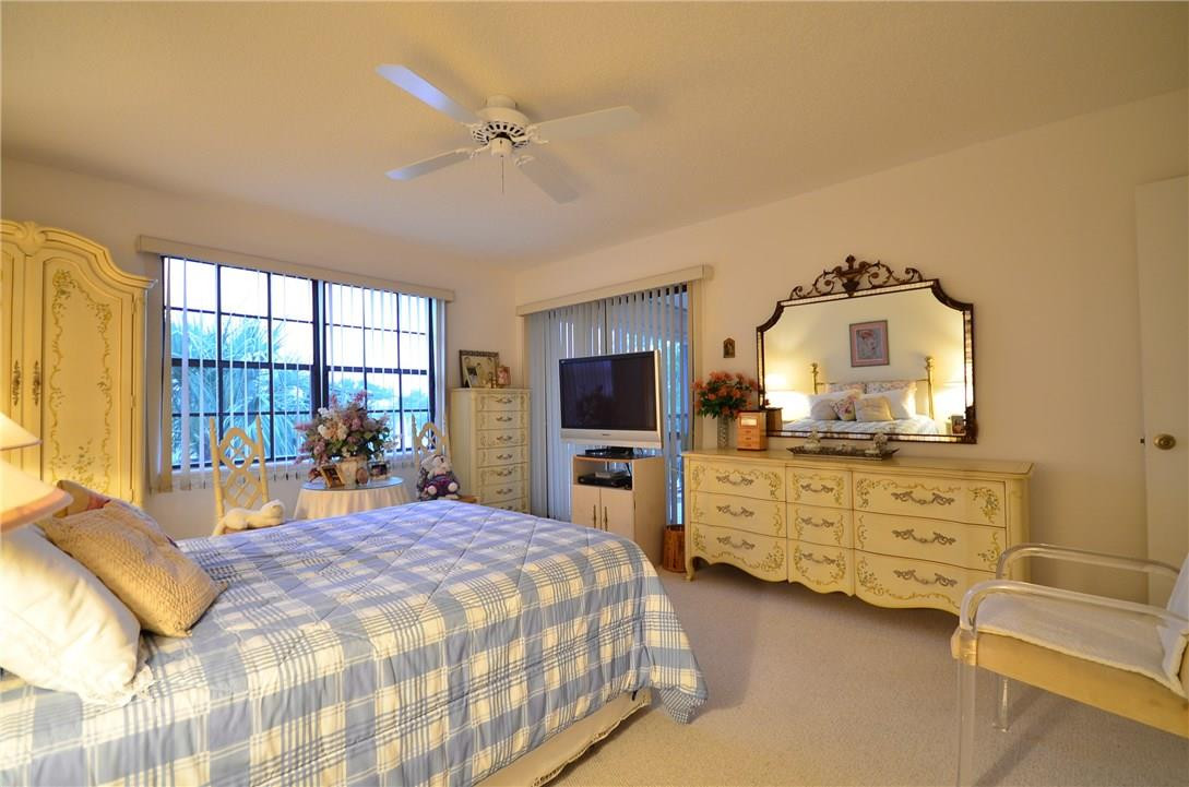 6761 Montego Bay Boulevard, Unit B Boca Raton, FL 33433 - Photo 28 of 34 a bedroom with a bed and a large window