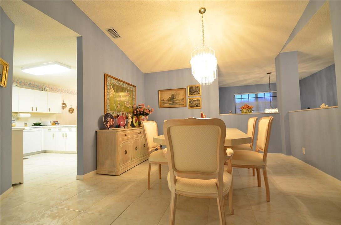 6761 Montego Bay Boulevard, Unit B Boca Raton, FL 33433 - Photo 10 of 34 a view of a dining room and livingroom with furniture wooden floor a chandelier