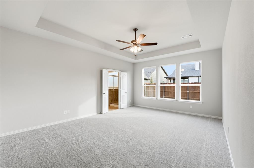 1244 Sabine River Lane Springtown, TX 76082 - Photo 12 of 26 Carpeted empty room with a raised ceiling and a ceiling fan