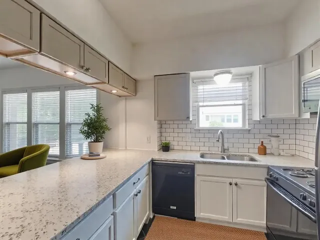 a kitchen with a sink a counter top space cabinets and stainless steel appliances