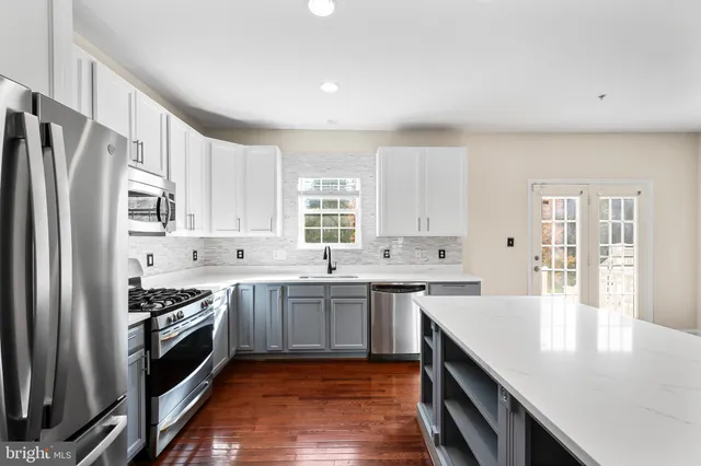 a kitchen with a refrigerator a sink and a microwave
