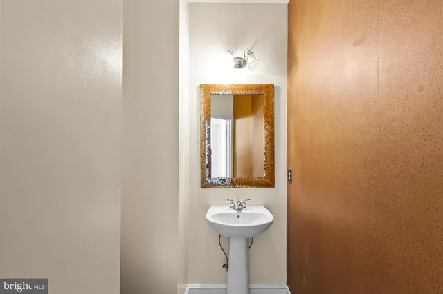 a bathroom with a sink and mirror with toilet