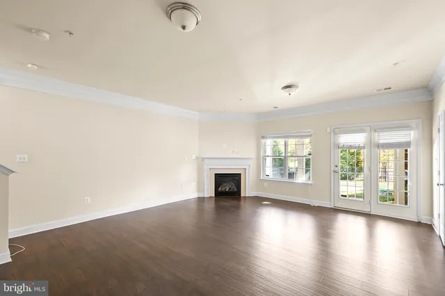 a view of an empty room with wooden floor and entryway