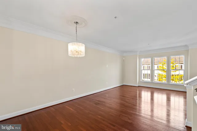 a dining room with wooden floor a chandelier a wooden table and chairs